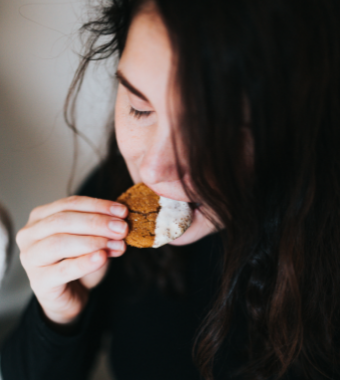 woman in black long sleeve shirt holding gingerbread cookie