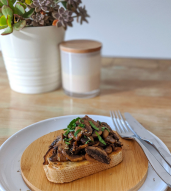Cooked mushrooms on sourdough toast displayed on wooden plate